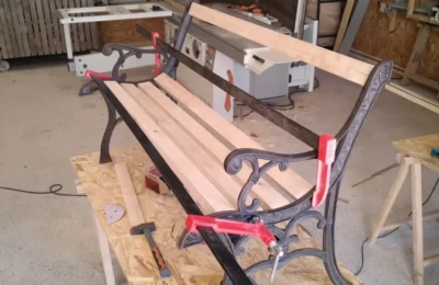 Le banc sur mesure : fabrication de l'assise sur l'ossature en fer forgé Banc en bois et fer forgé sur mesure dans un atelier
