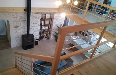 Détail de la rampe et de la protection vue en hauteur Détail de la rambarde d'un escalier intérieur suivi d'une protection en hêtre verni pour une mezzanine