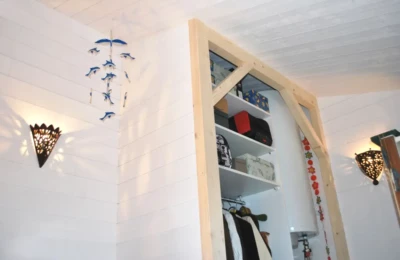 Espace de rangement ouvert avec à gauche une penderie et des étagères au-dessus et à droite un espace pour ballon d'eau Espace de rangement ouvert avec penderie, étagère et espace pour ballon d'eau