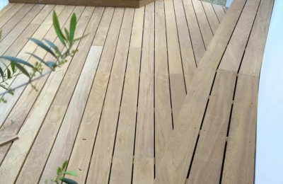 Les marches, un banc en bois Un détail de terrasse en bois avec des marches vers une entrée et un banc en bois longeant un mur extérieur