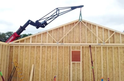 La pose d'un pignon à l'aide d'un bras mécanique Pose avec un bras mécanique d'un pignon latéral en ossature bois