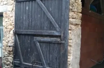 Le vantail gauche avec sa porte intérieure d'un portail à rénover Vantail gauche ancien de portail avec porte intérieure