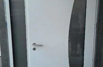 Porte d'entrée blanche – à gauche ouverture translucide – décoration incurvée à droite Une porte d'entrée de couleur blanche avec décoration incurvée