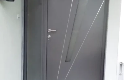 Porte d'entrée de couleur grise dans un renfoncement Une porte d'entrée de couleur grise décorée