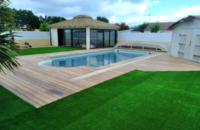 Une vue large de la terrasse en bois Une terrasse en bois autour d'une piscine vue large à droite