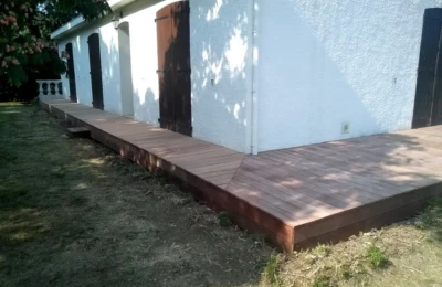 La terrasse rénovée en bois vue gauche Terrasse en bois aux abords d'une maison côté gauche